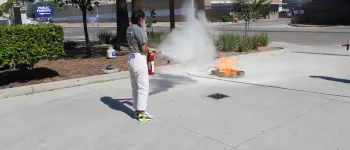 Young women puts out a fire in a fire extinguisher simulation