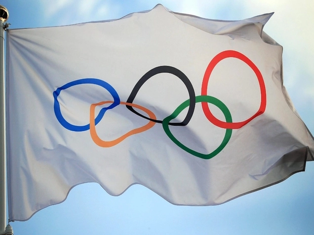 Image of flag of the Olympics, five multi-colored, interlocking rings on a white background.