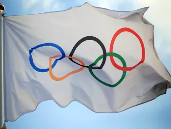 Image of flag of the Olympics, five mult-colored, interlocking rings on a white background the illustrate that Los Angeles will host the quadrennial sports event in 2028.