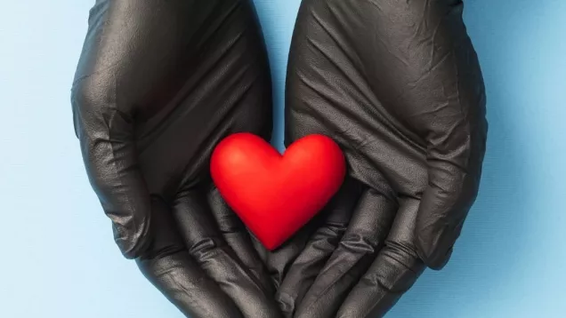 Heart in gloved hands