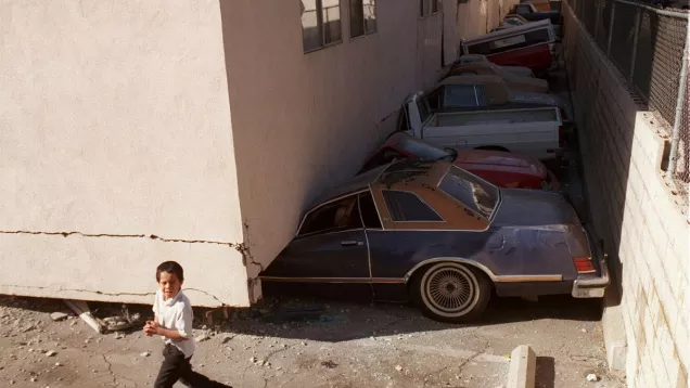 Cars parked underneath an apartment building smashed due to the Northridge Earthquake.