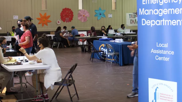 Photo of a resource fair in South LA, organized by LA Emergency Management to suuport victims of the 27th Street explosion. Tables and booth were worked by representives of may of the local agencies providing recovery assistance.