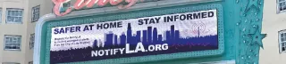 Image of an outdoor, rooftop billboard prompting the NotifyLA alert system.