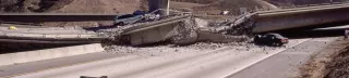 Photo showing large-scale earthquake damage to a Los Angeles freeway, including crashed cars and rubble 